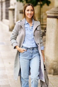 Optimistic female in outerwear strolling on street