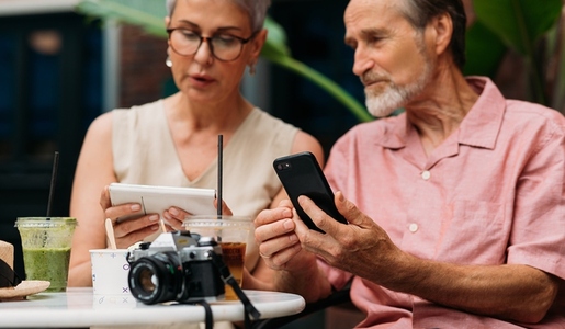 Two aged people holding their smartphones and talking