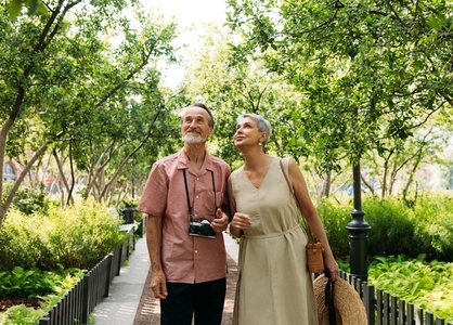 Two senior tourists walking in the park
