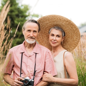 Portrait of two aged tourists standing on a wheat field