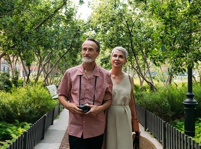 Mature woman and man walking in the park during summer vacation