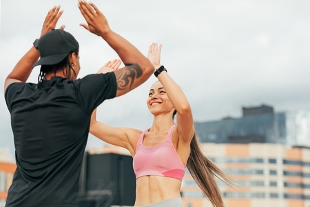 Young athletes giving each other high five after workout on the roof