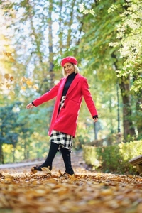 Fashionable woman on path with fallen leaves