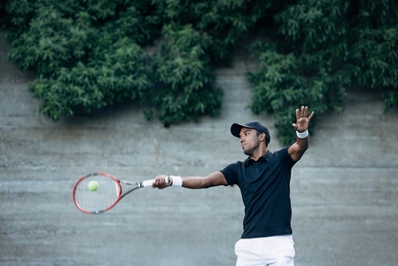 Professional tennis player hitting a ball with racket