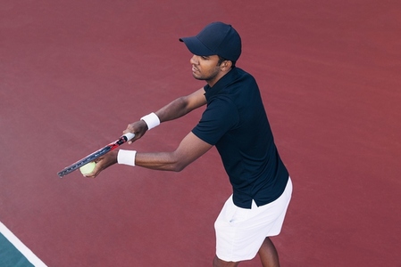 Tennis player preparing to serve a tennis ball during a tennis match