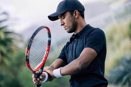Professional tennis player touching his arm during training
