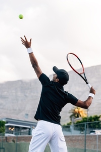 Side view of professional tennis player practicing outdoors