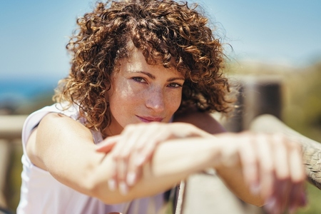 Young woman with curly hair and blurred hands