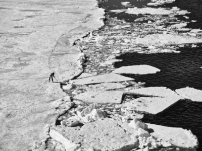 Scientist examining melting ice on glacier Antarctic Peninsula Weddell Sea Antarctica
