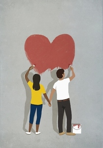 Couple holding hands painting red heart on gray wall