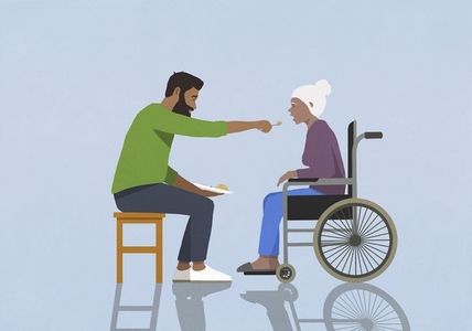 Adult son feeding aging mother in wheelchair
