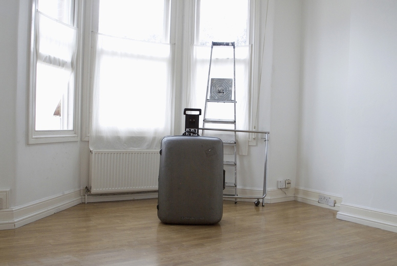 Empty room with suitcase and ladder