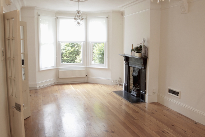Empty room with fireplace and bay window