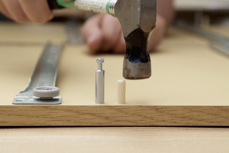 Close up of man's hands with hammer and flat pack detail