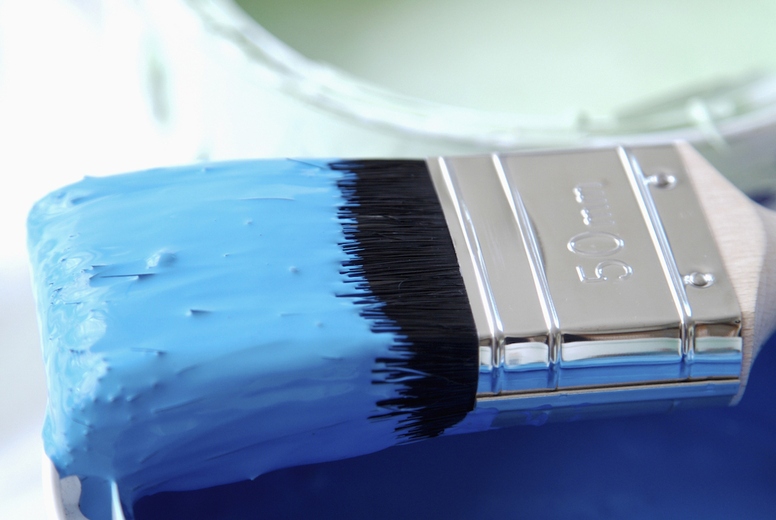 Close up of blue paint pot and paintbrush
