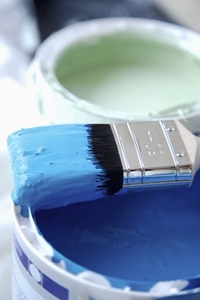 Close up of blue paint pot and paintbrush