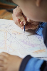 Close up of young boy drawing with color pencil
