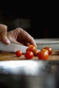Man039 s hands cutting cherry tomatoes