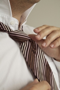 Extreme close up of man039 s hands tying a neck tie