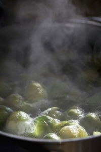 Brussels sprouts cooking in a pan of boiling water