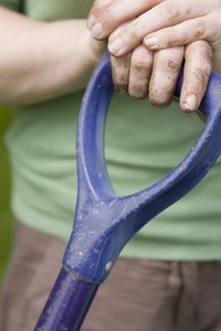 Extreme close up of hands on garden tool handle