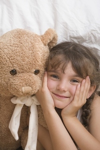 Close up of young girl with teddy bear smiling