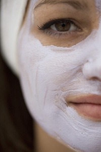 Extreme close up of young woman with mauve beauty mask