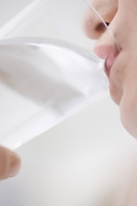 Extreme close up of young woman drinking glass of water