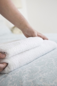 Close up of man hands adjusting towel on bed