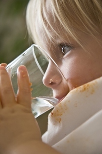 Close up of young blonde boy drinking water