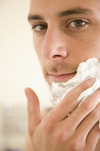 Close up of young man applying shaving cream