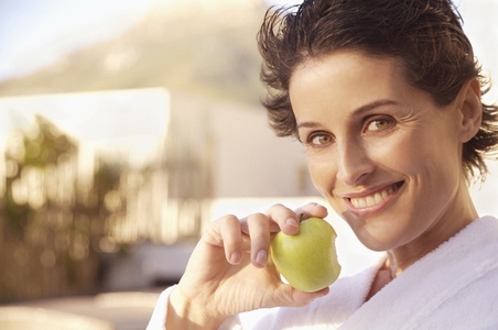 Smiling woman eating apple