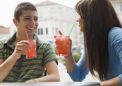 Portrait of young couple sitting and drinking cocktails