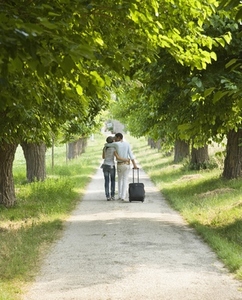 Young couple walking with suitcase and kissing