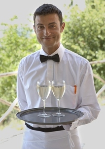 Waiter standing and holding tray with two glasses of white wine
