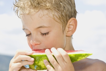 Young boy eating water melon