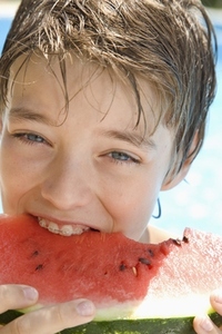 Young boy eating water melon