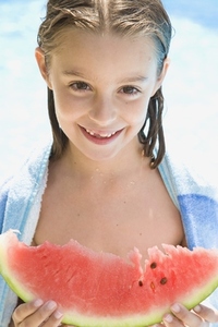 Smiling young girl holding water melon