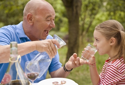 Granddad and granddaughter drinking water