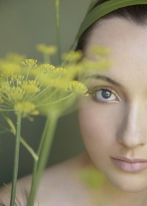 Young beautiful woman lost in thought with yellow flower