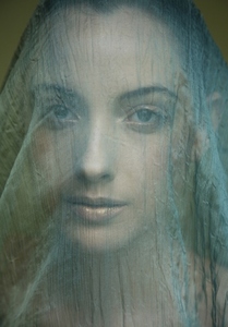 Portrait of young beautiful woman with light green veil