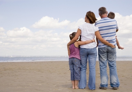 Back view of young family on a beach