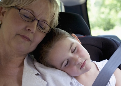 Grandmother and  granddaughter sleeping inside car