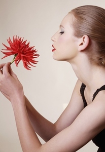 Portrait of young beautiful woman holding red dahlia