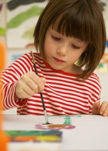 Portrait of young girl painting with watercolor