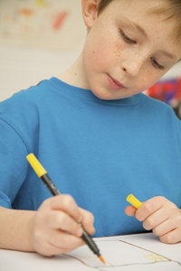 Portrait of young boy coloring with pen