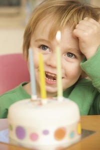 Toddler and birthday cake with three candles