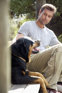 Man sitting under porch with his dog