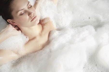 Portrait of a young woman having a bubble bath and relaxing