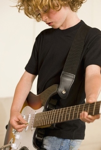 Young boy playing electric guitar